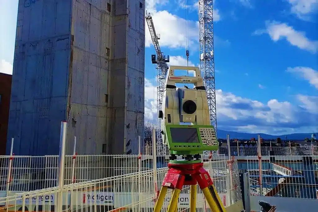 Surveyor operating a total station on a construction site